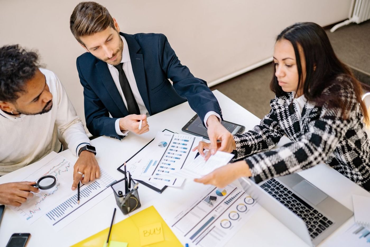 A small team reviewing charts and documents around a table