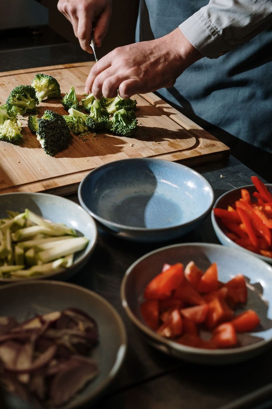 A chef preparing fresh vegetables on a board